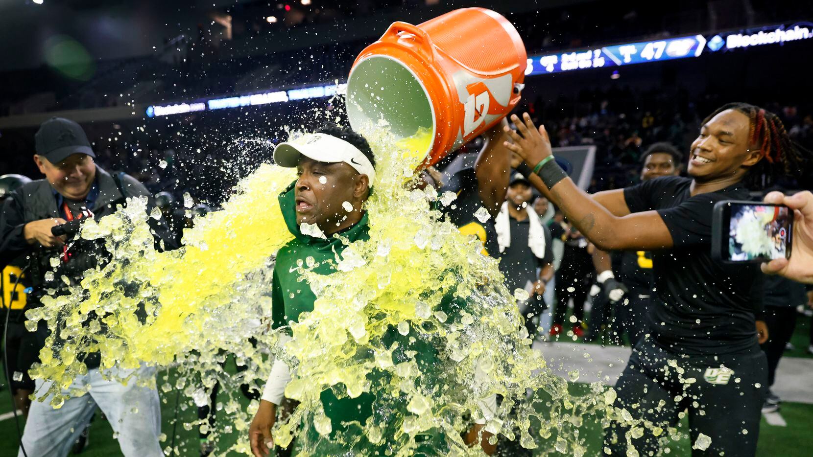 DeSoto head coach Claude Mathis is doused with the Gatorade cooler by his players following...