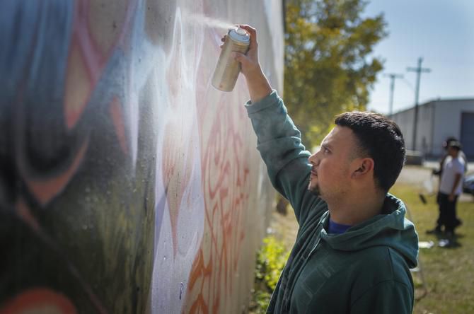 Graffiti artist Irvin Botello, also know as “Serfx,” paints on the approved space on...