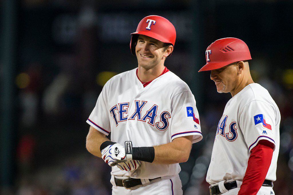 Texas Rangers center fielder Jared Hoying smiles at first base after hitting a single during...