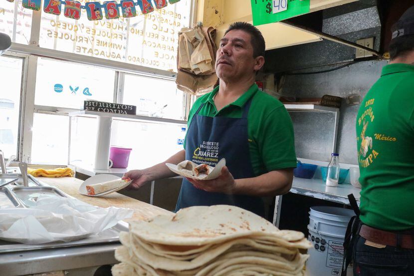 José Olivares prepares burritos at his family's business, Burritos El Compa, where he has...