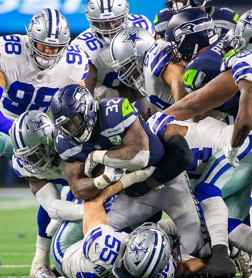 Seattle Seahawks running back Chris Carson (32) is brought down by Dallas Cowboys outside...