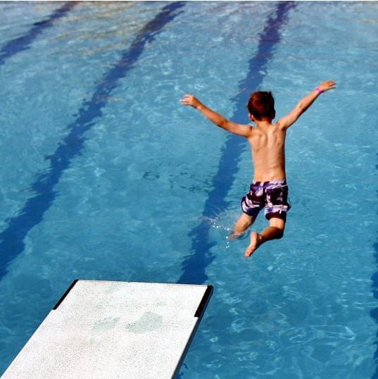 A boy  jumps off the low dive at Sun Valley Aquatic Center in Lewisville.