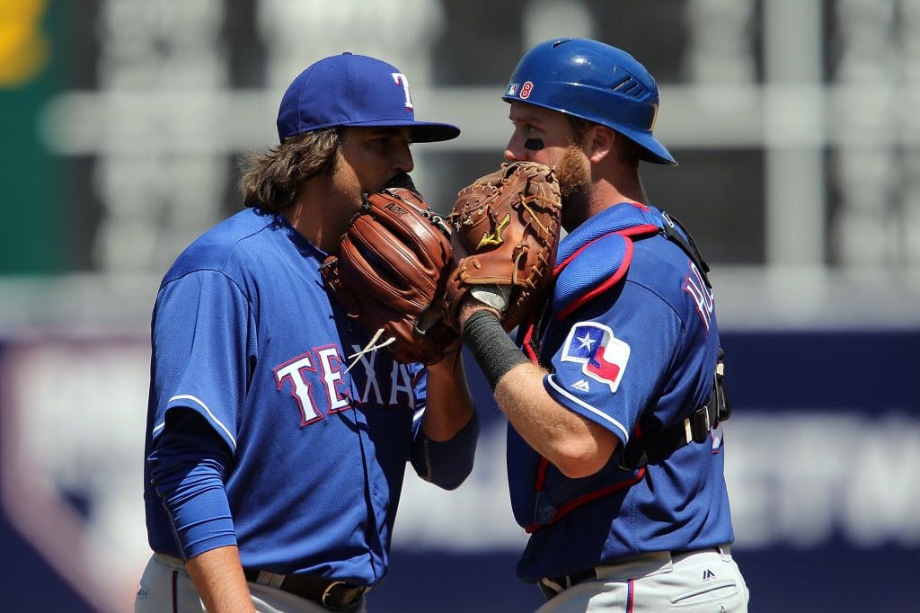OAKLAND, CA - MAY 18:  Luke Jackson #77 of the Texas Rangers talks with Bryan Holaday #8 of...