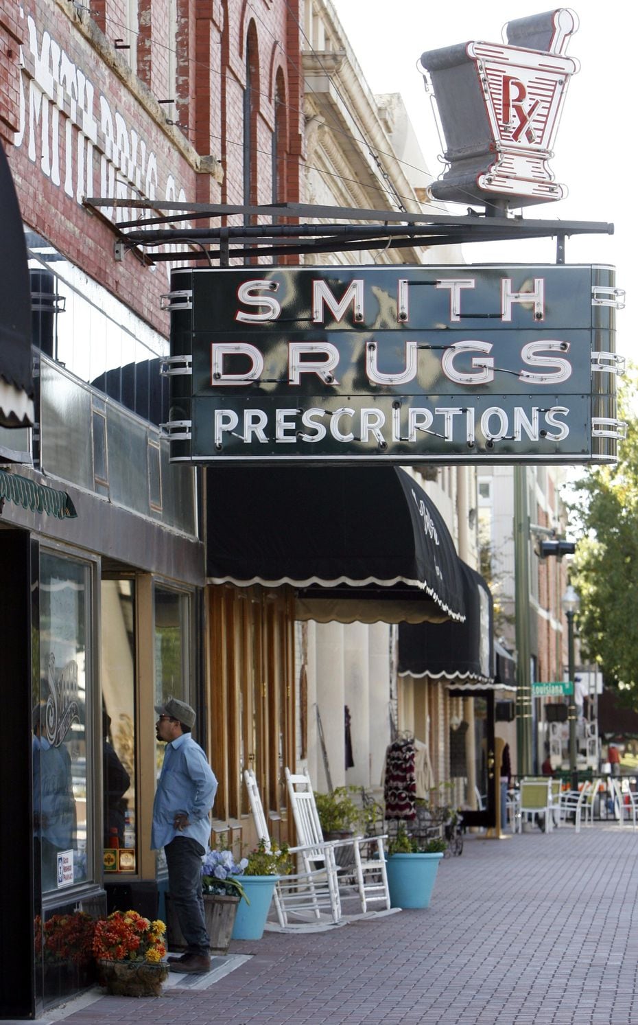 A man read signs in the store window requesting help to save the Smith Drug Co. store in...