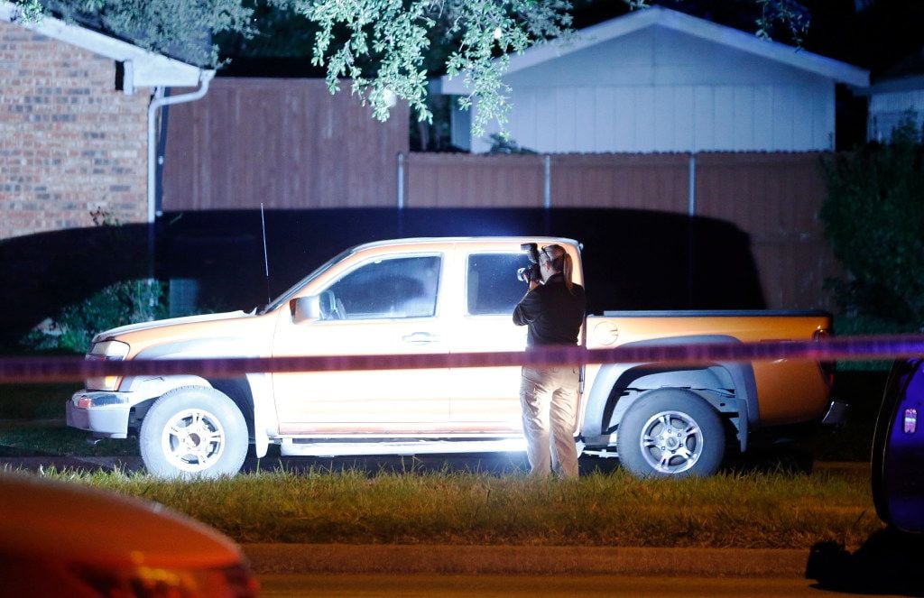 A police investigator takes photos at the scene of the shooting.