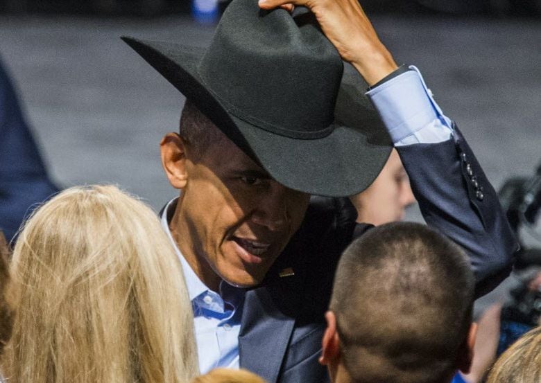 El Presidente Barack OBama se probó el sombrero vaquerto de un miembro de la audiencia que...