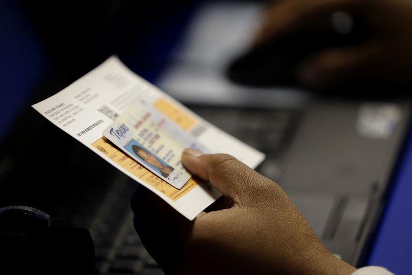 En esta foto de archivo del 2014, un agente electoral revisa una tarjeta de identidad de un...