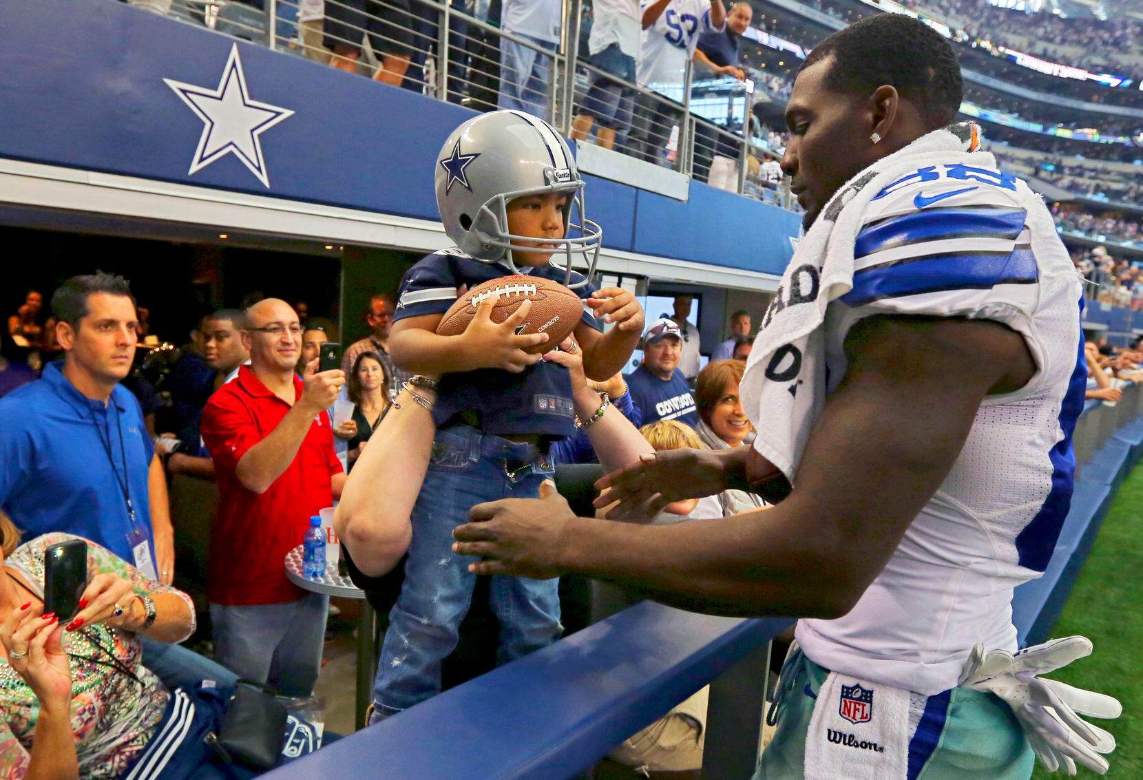 Dallas Cowboys wide receiver Dez Bryant (right) is handed his then 3-year-old son, Dez...