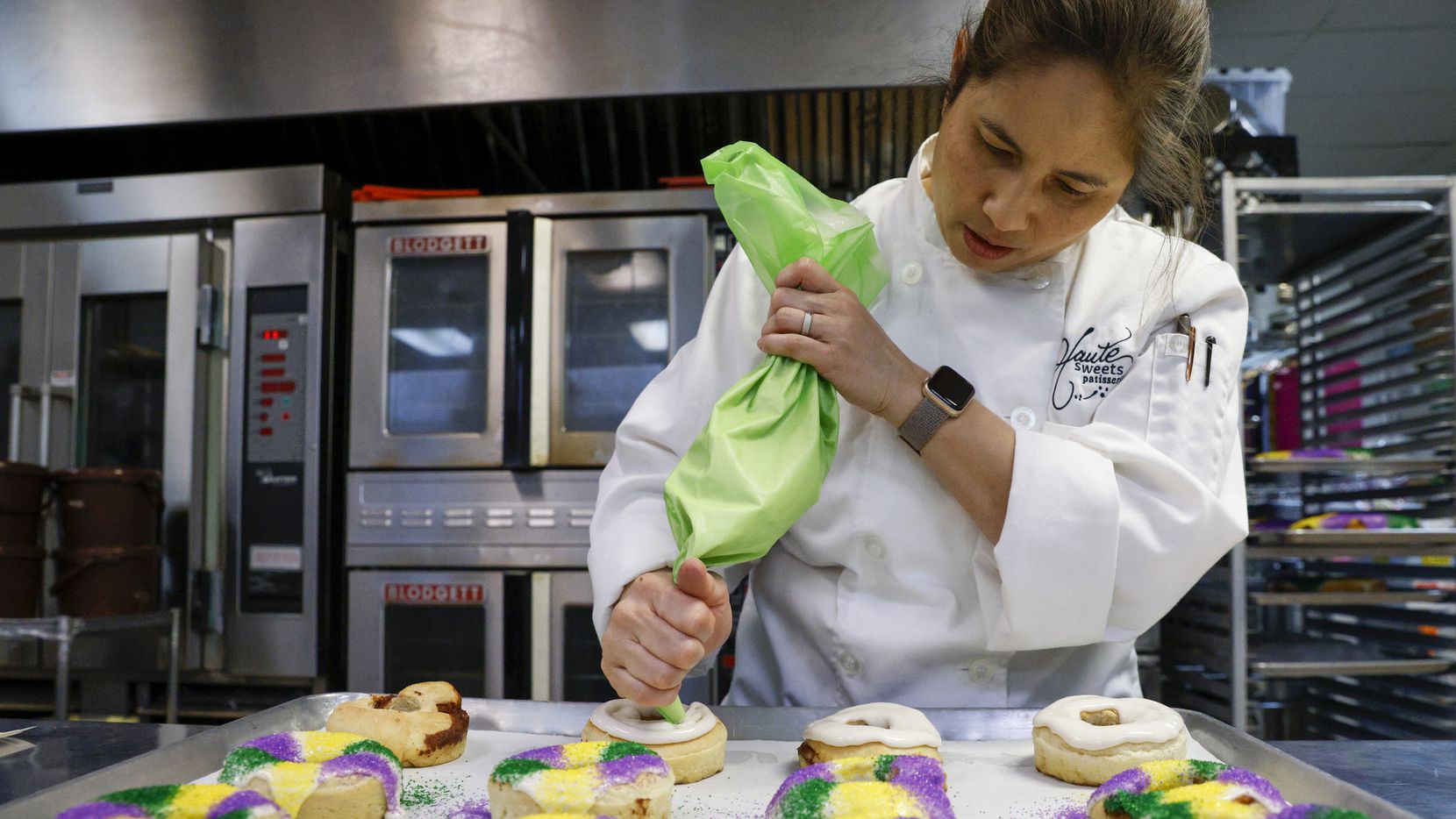 Owner Tida Pichakron ices miniature king cakes at Haute Sweets Patisserie in Dallas.