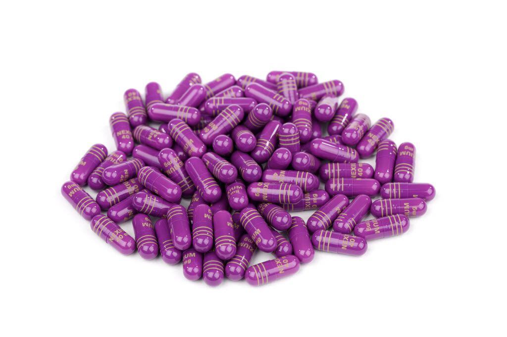 Pile of 40mg prescription Nexium pills, isolated on white. Nexium is prescribed to treat...