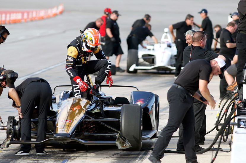 IndyCar Series driver James Hinchcliffe climbs from his car after racing with fellow driver...