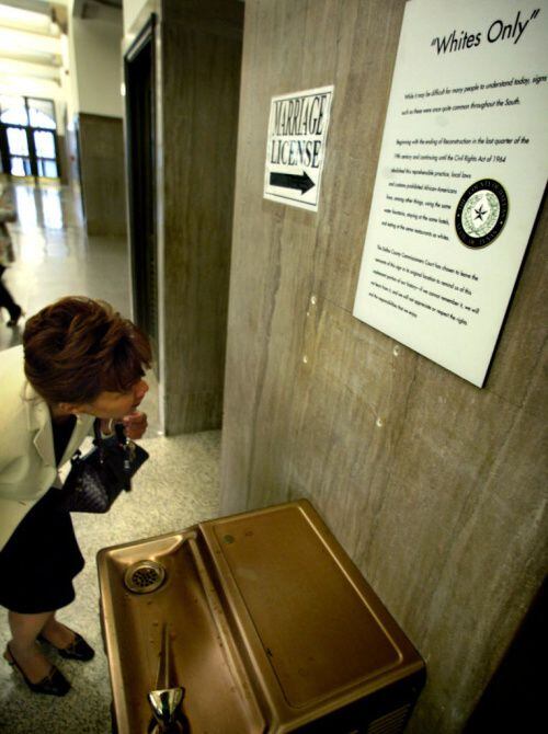 The “Whites Only” sign over a water fountain in the Dallas County Records Building was faint...