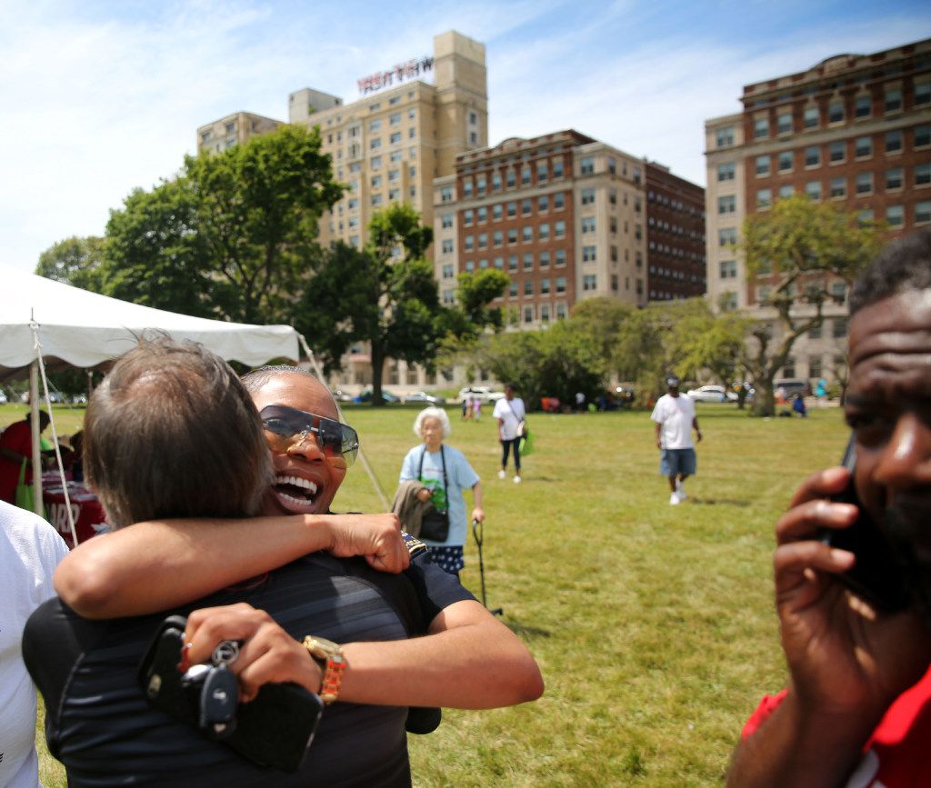 Hall (left, facing camera) hugs Jesse Gonzales, a community liaison for the Detroit Police...