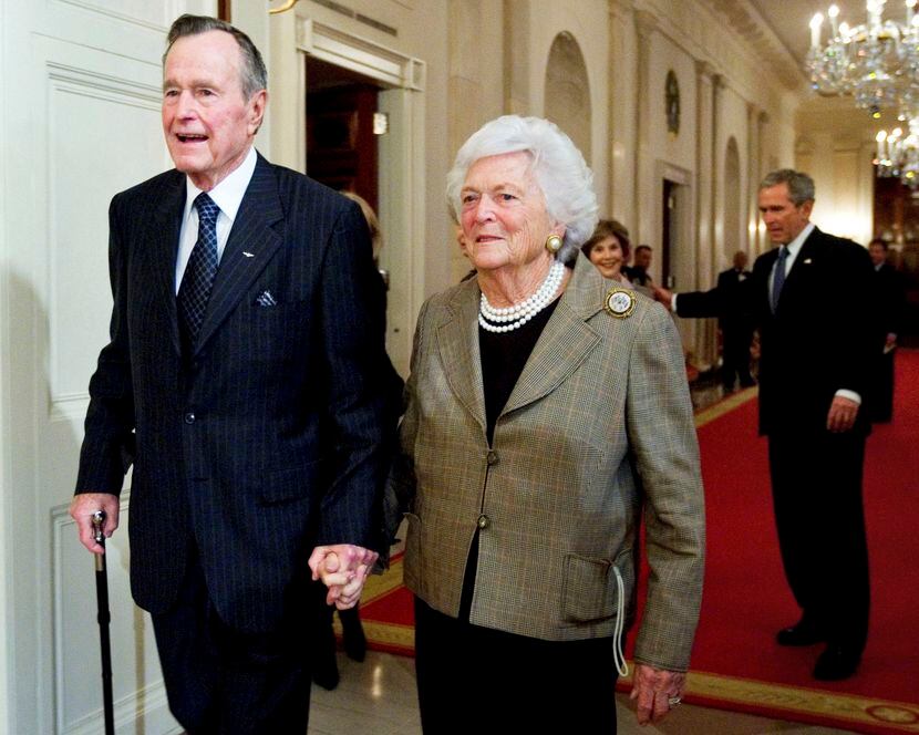 In this Jan. 7, 2009, file photo, former President George H. W. Bush, left, walks with his...