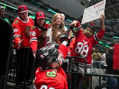 Chicago Blackhawks right wing Patrick Kane (88) gives a puck to a fan before an NHL hockey...