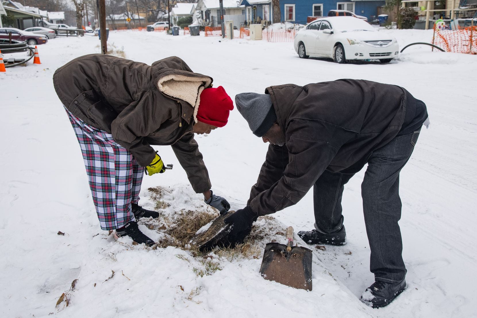 Patricia Broadway (left) and Leon Morris put the cover back after shutting the water off in...