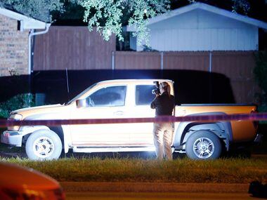 A police investigator takes photos at the scene of the shooting.