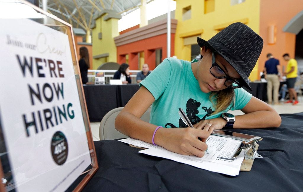 FILE - In this Oct. 4, 2017 file photo, job seeker Alejandra Bastidas fills out an application at a job fair in Sweetwater, Fla.  U.S. workersâ wages and benefits grew 2.6 percent last year, the fastest 12-month pace since the spring of 2015. The 12-month gain in wages and benefits came despite a slight slowdown at the end of last year with wages and benefits rising 0.6 percent in the fourth quarter, a tiny dip from a 0.7 percent gain in the third quarter. Still, the 12-month gain was an improvement from a 2.2 percent gain for the 12 months ending in December 2016. (AP Photo/Alan Diaz, File)