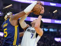 Dallas Mavericks center Dwight Powell (7) is fouled by Golden State Warriors forward Kevon...