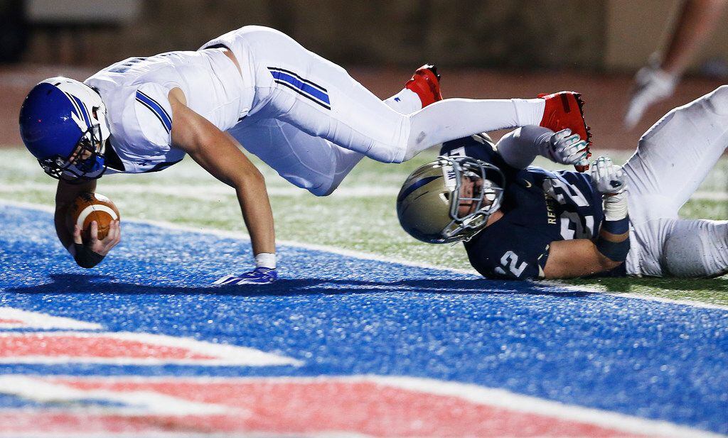 Trinity Christian's Elijah yelverton (19) dives in for the touchdown as Austin Regents Thomas Scully (22) tackles him during the second half of play at the TAPPS Division II State Championship game at Waco Midway's Panther Stadium in Hewitt, Texas on Friday, December 6, 2019. Trinity Christian defeated Austin Regents 48-19. (Vernon Bryant/The Dallas Morning News)
