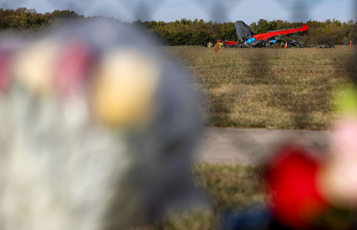 Flowers are left along the fenceline of the Dallas Executive Airport on Sunday, Nov. 13,...