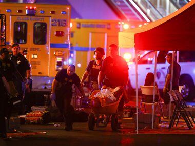 A wounded person is walked in on a wheelbarrow as Las Vegas police respond to a mass...
