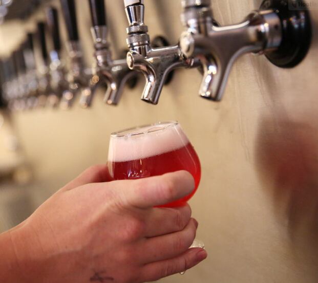 Beertender Byron Canulla fills a draft beer at the Bearded Monk in Denton, Texas on Aug. 25,...