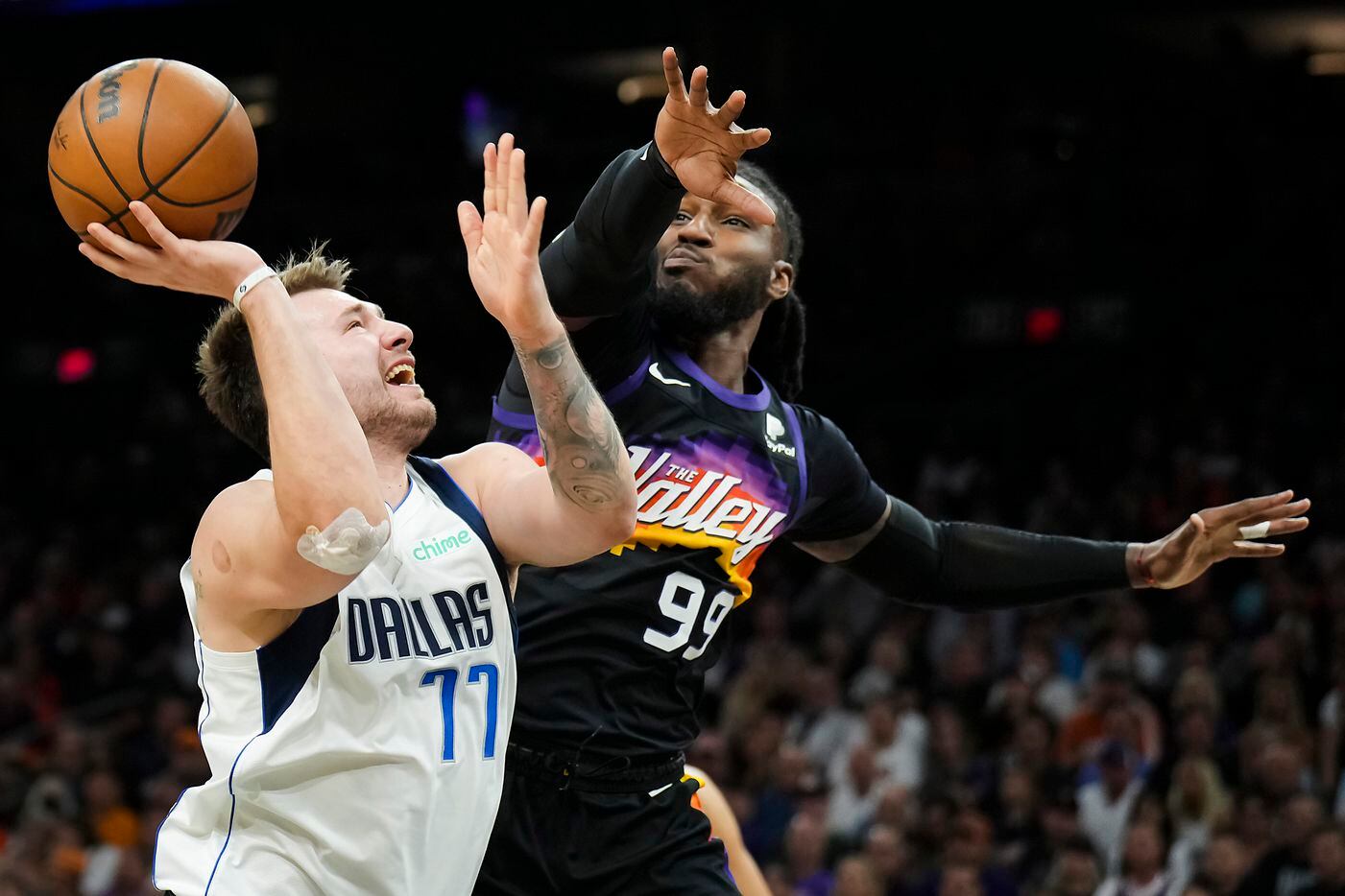 Dallas Mavericks guard Luka Doncic (77) is fouled by Phoenix Suns forward Jae Crowder (99)...