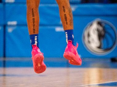 Tattoos on the calves of Dallas Mavericks guard Carlik Jones (23) read “FEAR NOTHING” and...