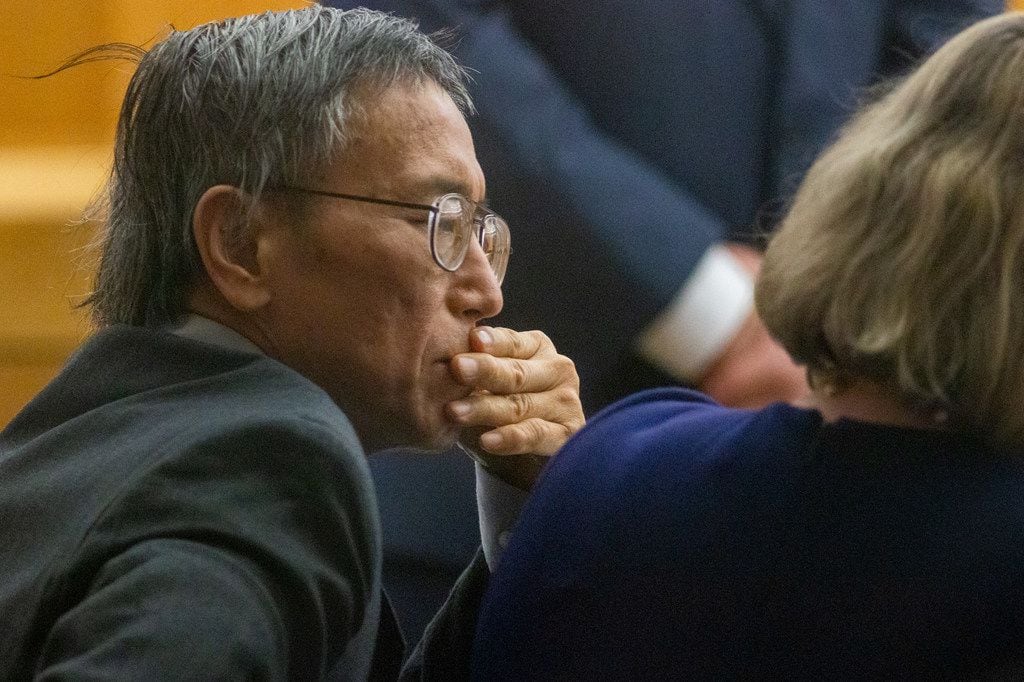 Former doctor George Guo looks at prosecutor evidence shown during his capital murder trial.