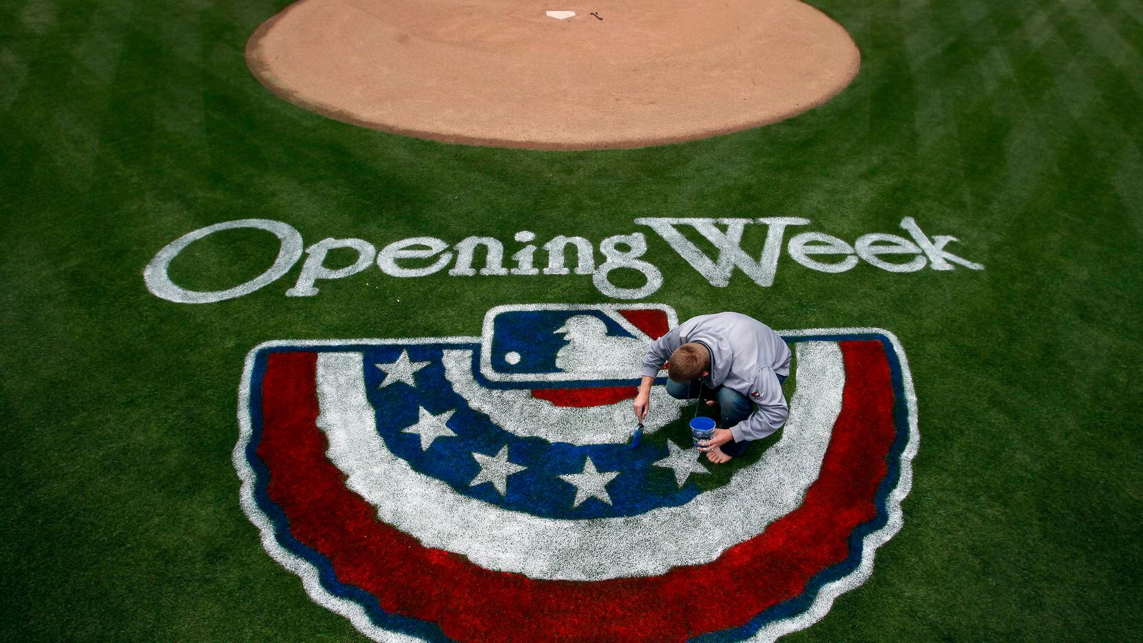 Steve Lord, assistant director of MLB Grounds for the Texas Rangers  paints the Opening Day...