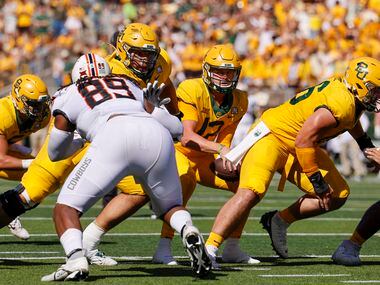 Baylor quarterback Blake Shapen (12) takes the snap from offensive lineman Jacob Gall (66)...