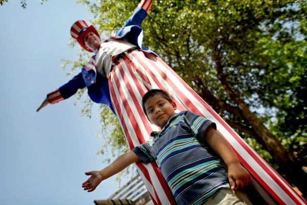 Luis Guerrero mimics Brad Johnson, who is portraying a very tall version of Uncle Sam, at...