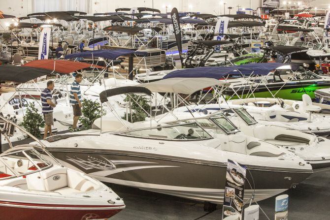 Two men look over the boats on display at the DFW Boat Expo.