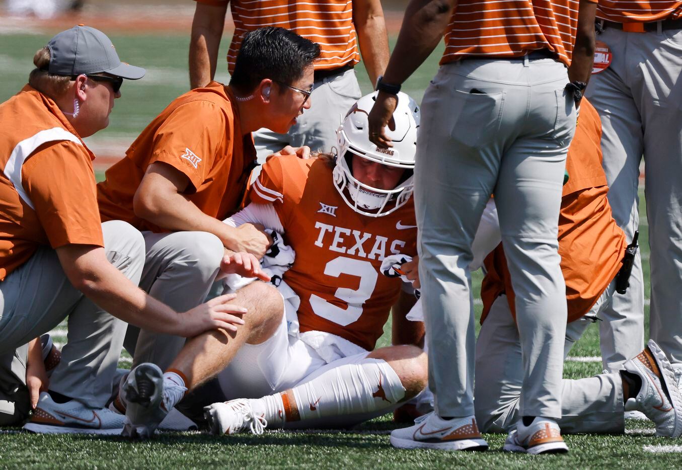 Texas Longhorns quarterback Quinn Ewers (3) is tended to after he took a hard hit from the...