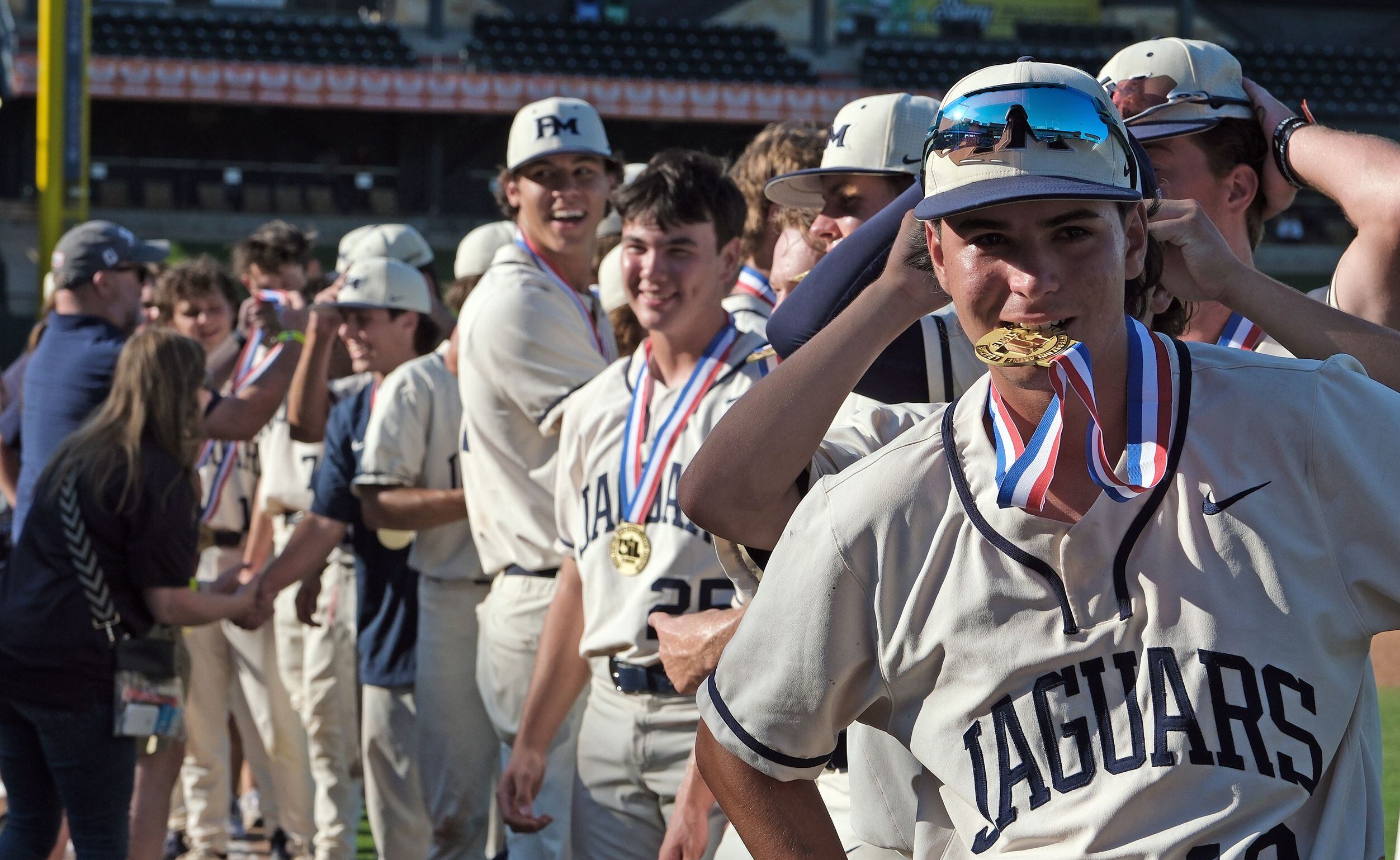 Flower Mound Lucio Lagreca, (19), holds his championship medal in his mouth as the team...