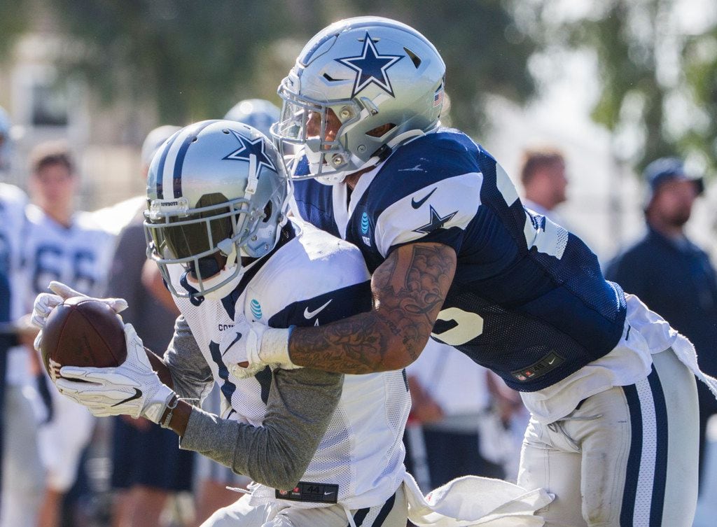 Cowboys safety Darian Thompson (right) tackles wide receiver Reggie Davis during a practice...