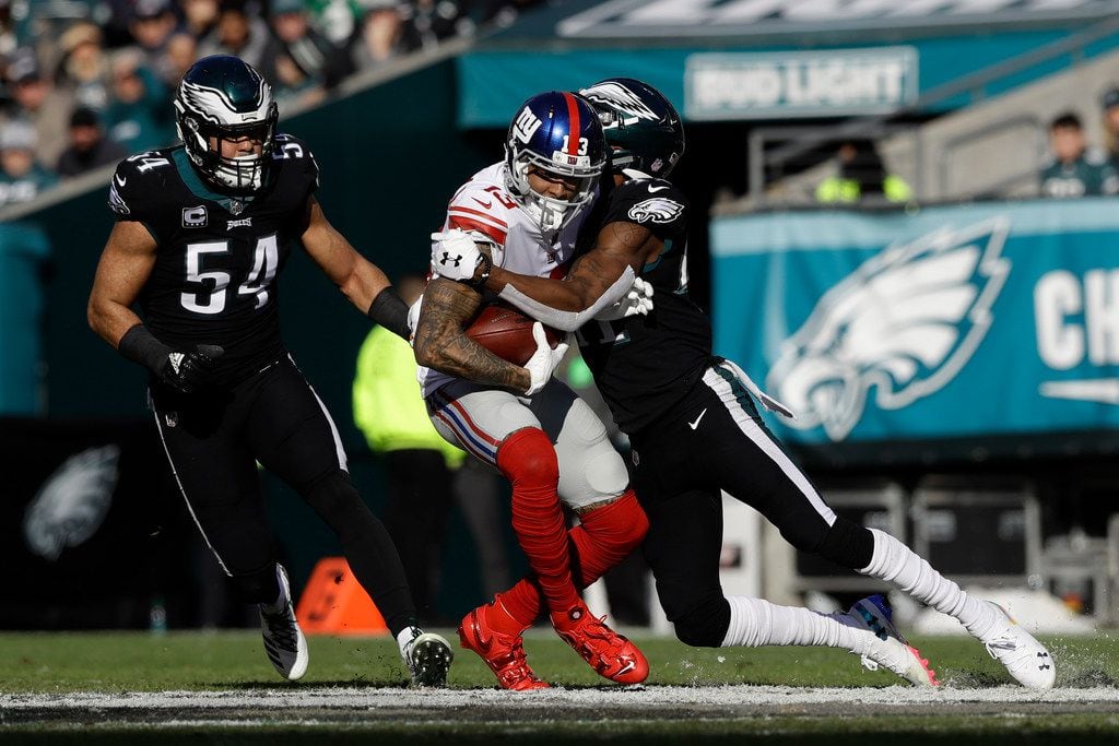 Philadelphia Eagles cornerback DeVante Bausby, right, tries to stop New York Giants wide receiver Odell Beckham (13) as Eagles Kamu Grugier-Hill (54) looks on during the first half of an NFL football game, Sunday, Nov. 25, 2018, in Philadelphia. (AP Photo/Michael Perez)