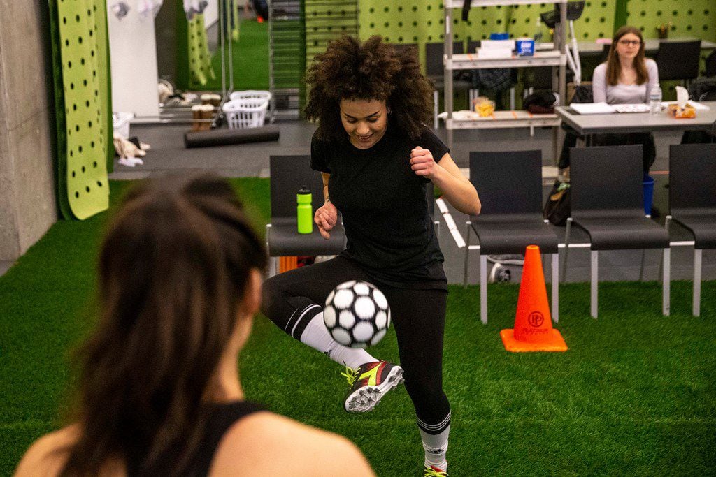 Lauren Steele practices soccer skills with Sydney Lo during a rehearsal for a production of...