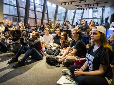 Students listen as members of the Bryan Adams High School Literary Club read their poetry...