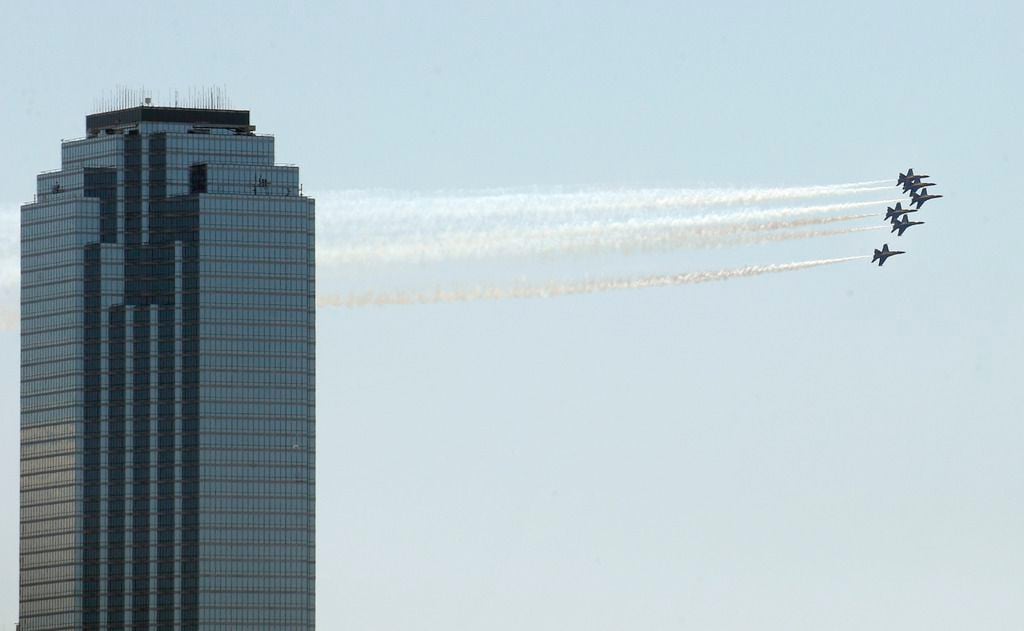 The U.S. Navy Blue Angels fly past the Bank of America building in downtown Dallas during...