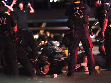 Police have protestors lie on the ground on the Margaret Hunt Hill bridge, while arresting...