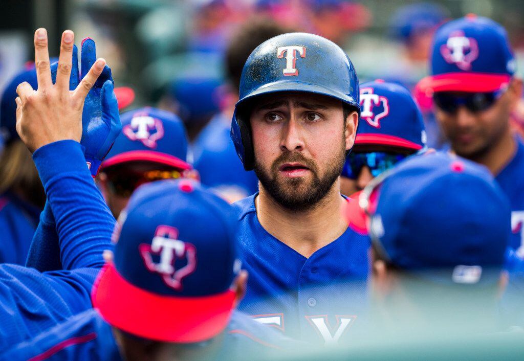 Texas Rangers designated hitter Joey Gallo (13) gets high fives in the dugout after scoring...