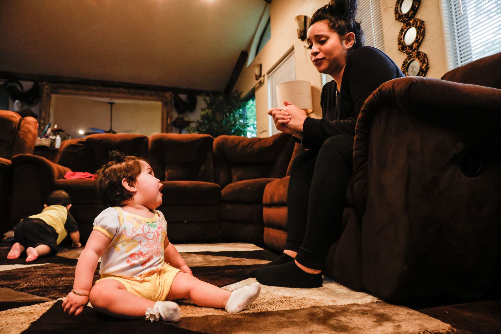Brenda Raymundo plays with her daughter Amara Ibarra in her living room in west Oak Cliff.