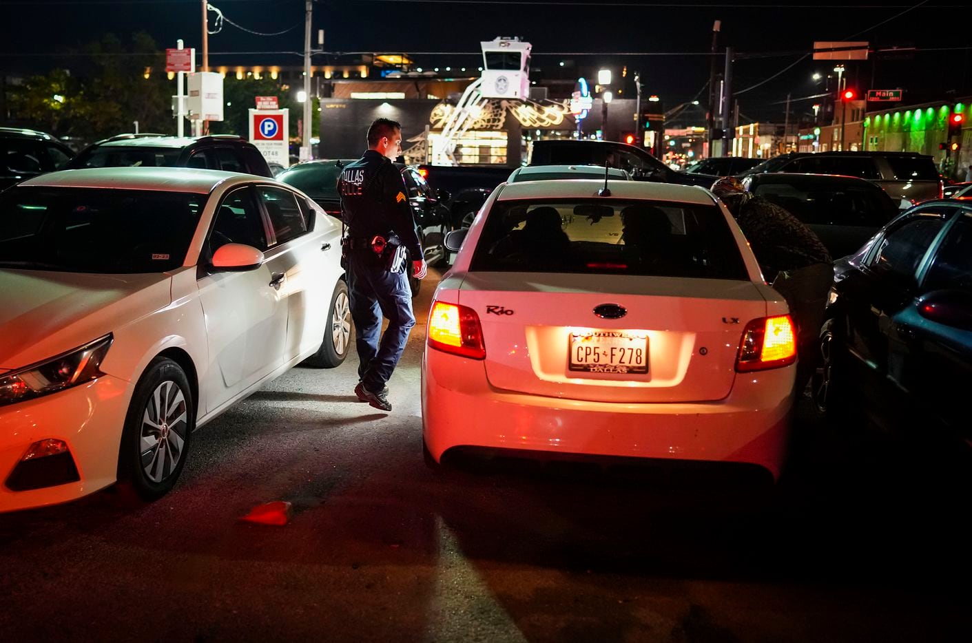 Dallas police Sgt. Boz Rojas checks on people in parked cars in parking lot in Deep Ellum on...