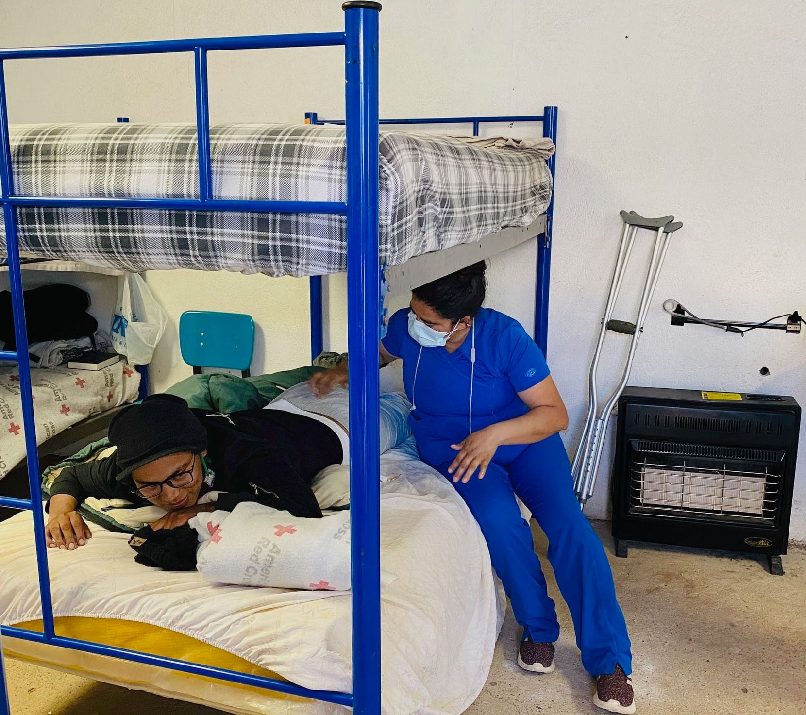 Jhon Jairo Ushca Alcoser está recibiendo tratamiento por una fractura en la espalda luego de caer 30 pies mientras trataba de escalar el muro delimitador.  Brenda Yazmin Nevarez, directora de servicios médicos y enfermera paramédica, le dio una inyección el miércoles para ayudar a aliviar el dolor.
