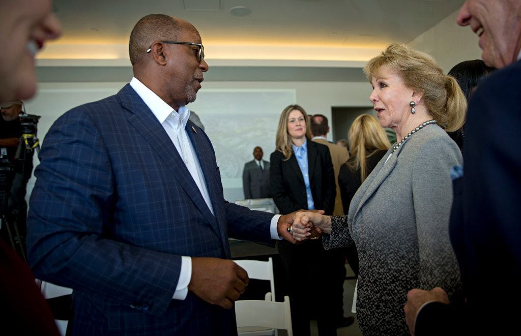 Former Dallas Mayor Ron Kirk (left) shakes hands with Annette Simmons following a press...