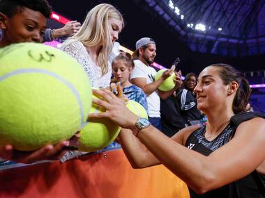 Caroline Garcia of France gives autographs to fans after winning against Coco Gauff of the...
