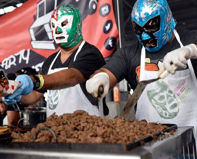 Taco vendors wear lucha libre masks during Taco Libre festival at Dallas Farmers Market.