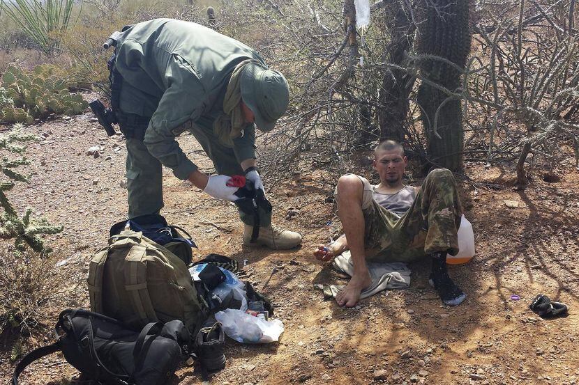 Un agente de la Patrulla de Fronteras asiste a un migrante que fue encontrado deshidratado...